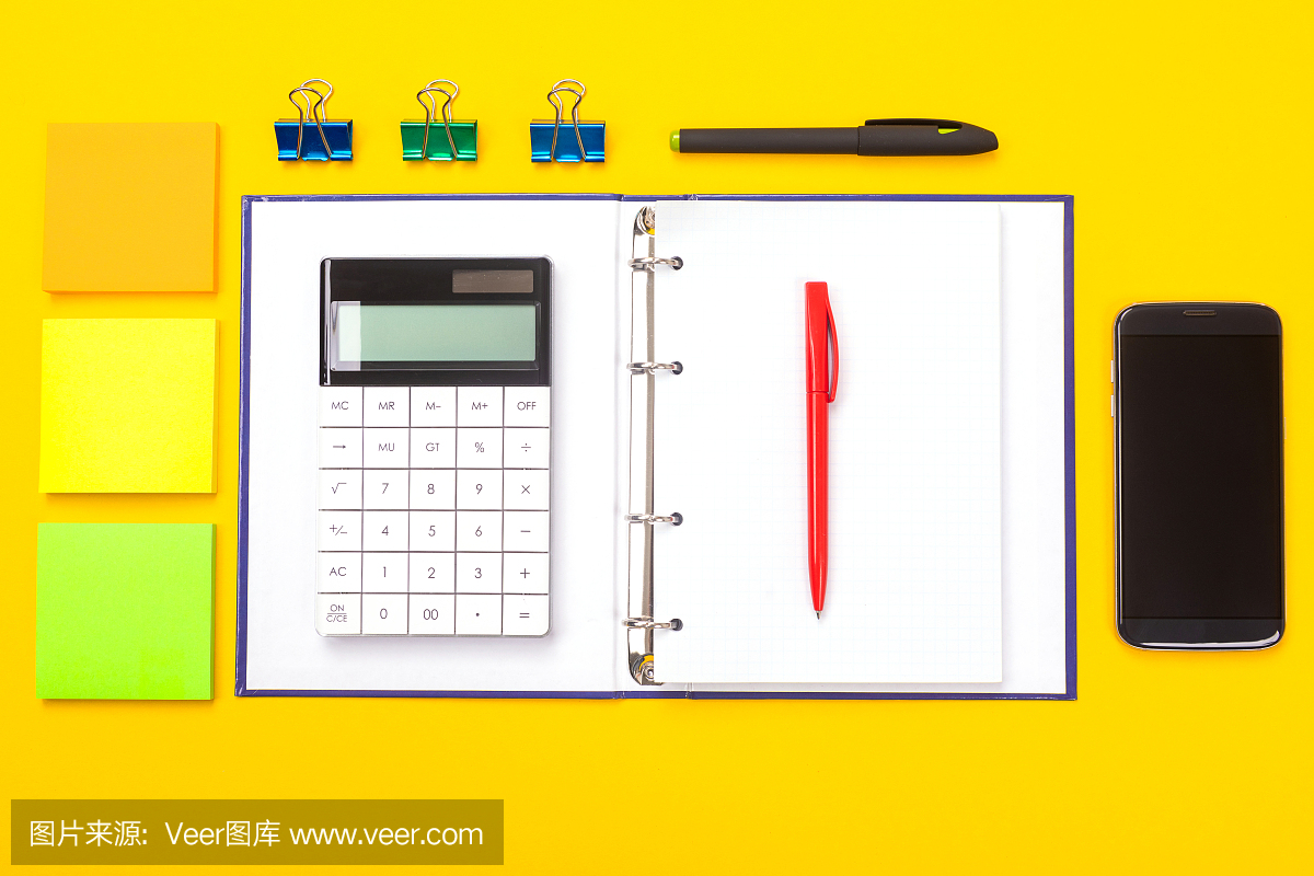 俯視圖的工作空間桌子與手機(jī),筆記本和鋼筆孤立在黃色的背景